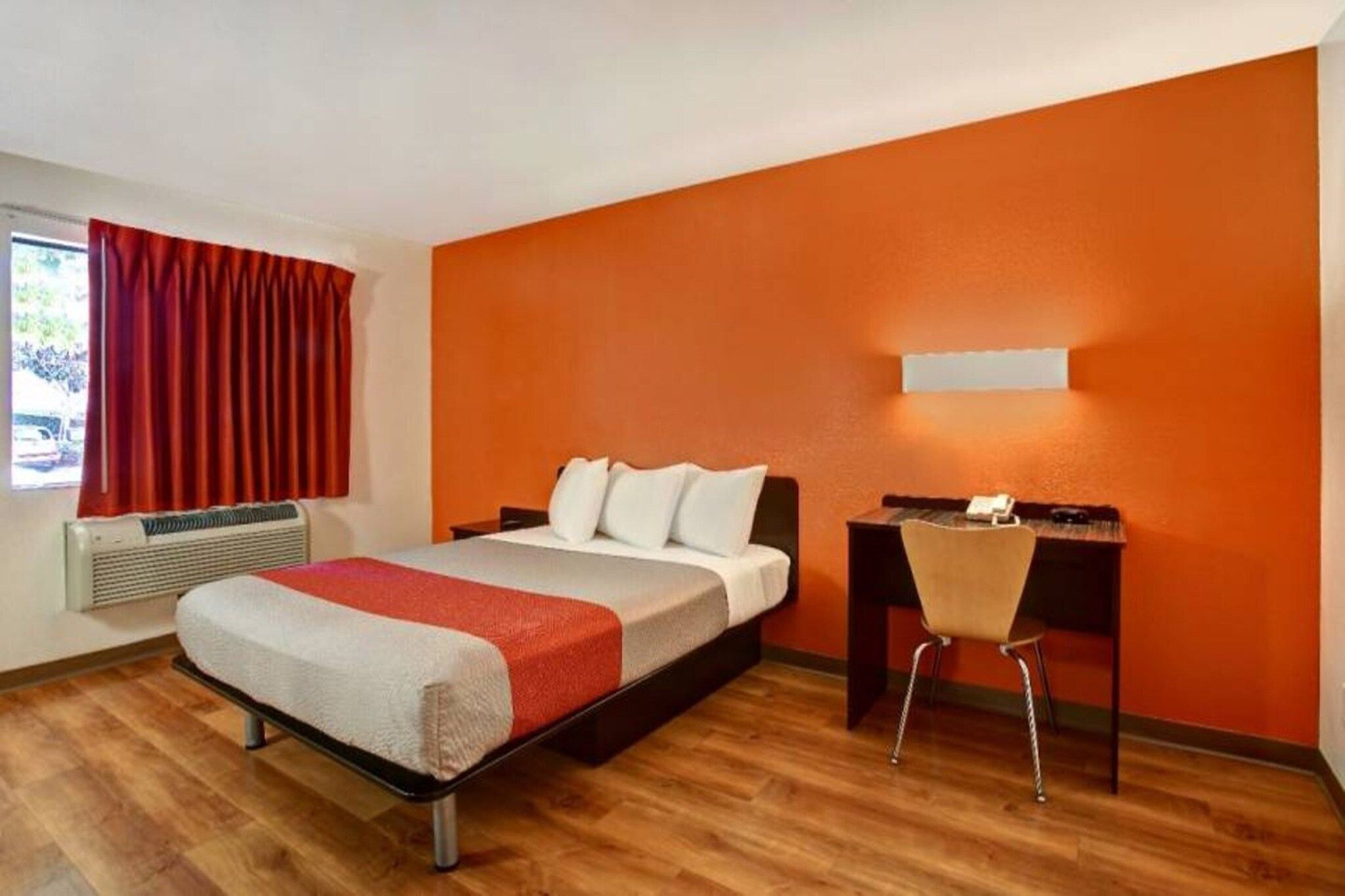 Ein Hotelzimmer mit einem Bett, einem Schreibtisch und einem Stuhl.