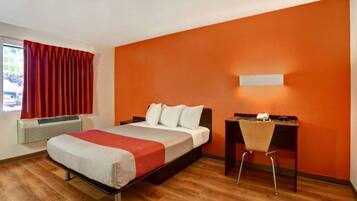 Ein Hotelzimmer mit einem Bett, einem Schreibtisch und einem Stuhl.