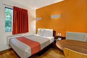A hotel room with a bed, a table, a chair, a telephone, and a window with curtains. - MS6 California|1 Queen Bed | (Sunnyvale)