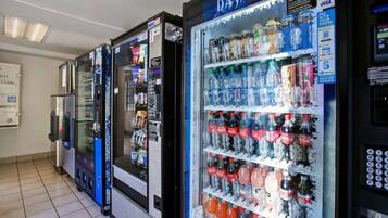 A row of self-service beverage vending machines with various drink options.