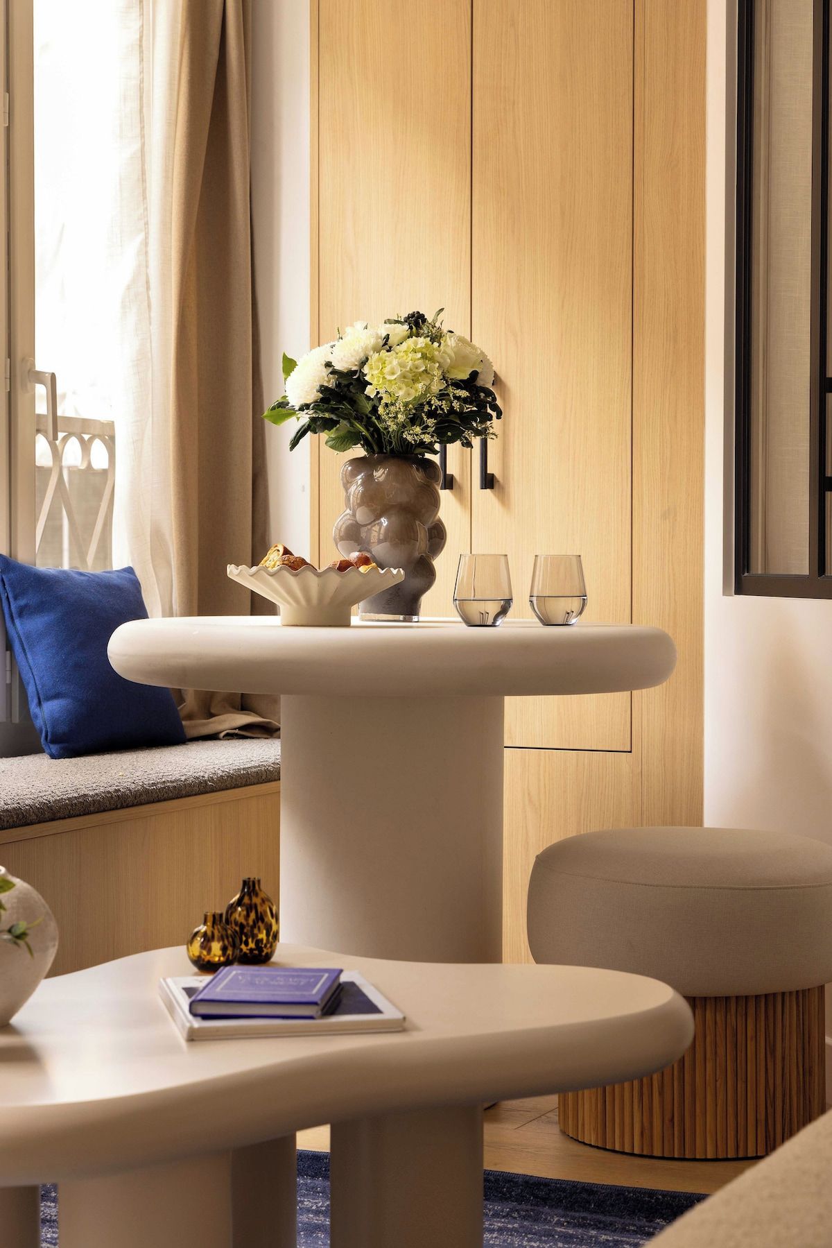 Un salon moderne avec un canapé, une table basse et une table d’appoint.