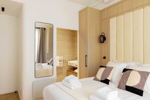 A hotel room with a bed, a mirror, a wardrobe, and a bathroom visible through an open door. - A Real Paris Experience : Walk to Montmartre ! (Paris)