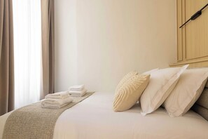 A hotel room with a neatly made bed, a set of folded towels, and a large window with curtains. - A Real Paris Experience : Walk to Montmartre ! (Paris)