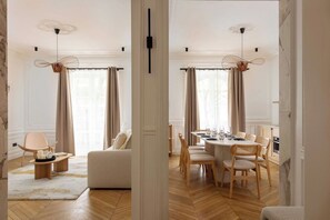 A modern interior with a dining area, a sofa, and a chair. - A Real Paris Experience : Walk to Montmartre ! (Paris)