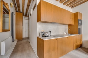 Eine moderne Küche mit Holzausstattung, einer Arbeitsplatte und einem eingebauten Ofen.