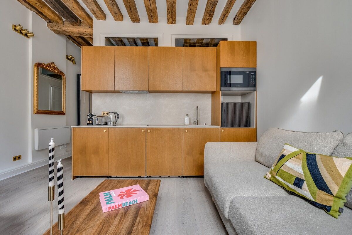 A compact living space with a kitchenette, a sofa, and a coffee table.