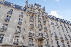A multi-story building with balconies, large windows, and a classic architectural style. - Peaceful Studio for a Calm & Soothing Retreat (Paris)