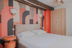 A bedroom with a bed, a nightstand, a wall-mounted lamp, and a wardrobe. - Clean & Modern Flat near Vibrant Bastille (Paris)