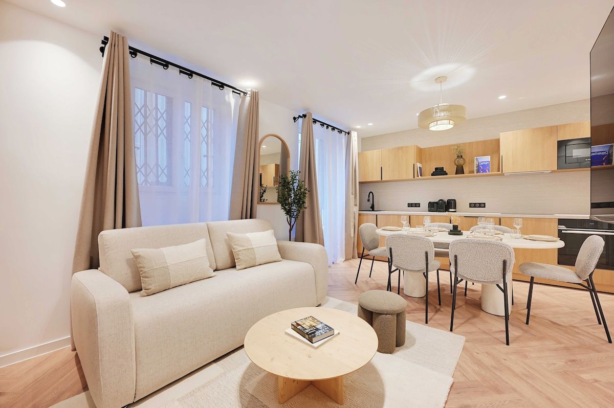 Un salon moderne comprenant un canapé, une table basse et un coin repas avec des chaises.