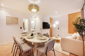 A modern dining area with a round table, chairs, and a ceiling light fixture. - Elegant & Calm Flat close to Eiffel Tower (Paris)