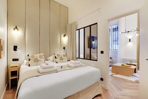 A modern hotel room with a large bed, bedside tables, a TV, and a view of the outside. - Contemporary Flat by Champs Elysées & Parc Monceau (Paris)