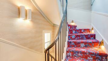 A staircase with a curved railing and patterned carpet.
