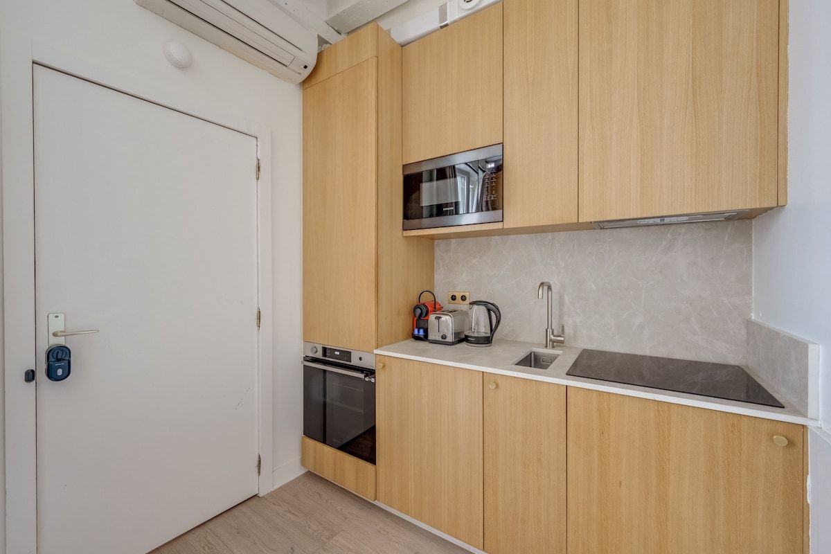 Une cuisine compacte avec des meubles en bois, un four à micro-ondes, un grille-pain et un évier.
