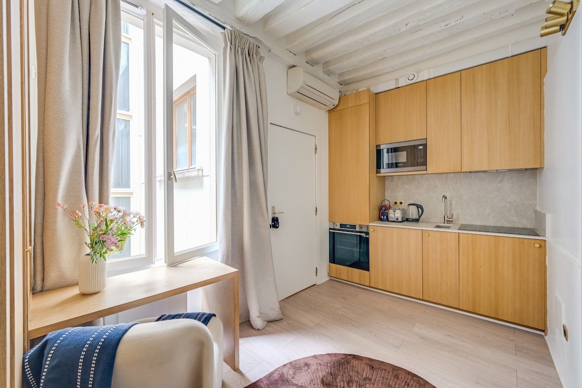 Une cuisine moderne avec des meubles en bois, un four encastré et un four à micro-ondes.