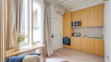 Une cuisine moderne avec des meubles en bois, un four encastré et un four à micro-ondes.