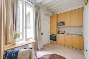 Een moderne keuken met houten kastjes, een inbouwoven en een magnetron.