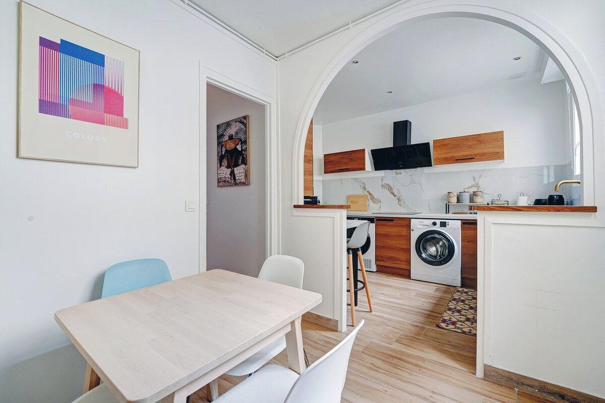 A compact kitchen with a washing machine, wooden cabinets, and a tiled backsplash.