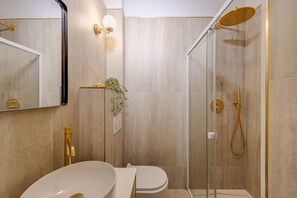 A modern bathroom with a large mirror, a round sink, a toilet, and a glass-enclosed shower area. - Incredible Location - Central Studio near Louvre (Paris)