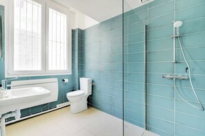 Ein Badezimmer mit einem weißen Waschbecken, einer Toilette und einer Dusche inklusive Handbrause.