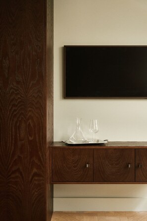A wooden cabinet with a blackboard above it, a glass pitcher, and two wine glasses on a tray. - Curated Home for an Unforgettable Experience (Paris)