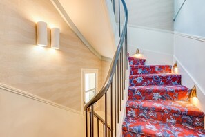 A staircase with a curved railing and patterned carpet. - Parisian Escape in Central Le Marais (Paris)
