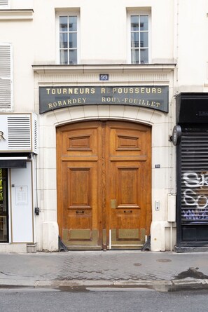 A double wooden door with a sign above it. - Design Flat in Trendy Oberkampf Area (Paris)