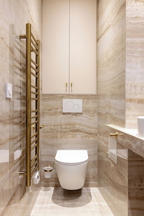 Een moderne badkamer met toilet, een wastafel en een douchehoek.