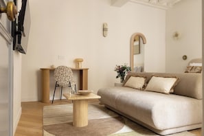 Een woonkamer met een bank, een salontafel, een stoel en een bijzettafeltje.