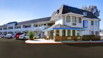 A motel with a central building and a smaller attached structure, both featuring a flat roof and a single-story design.