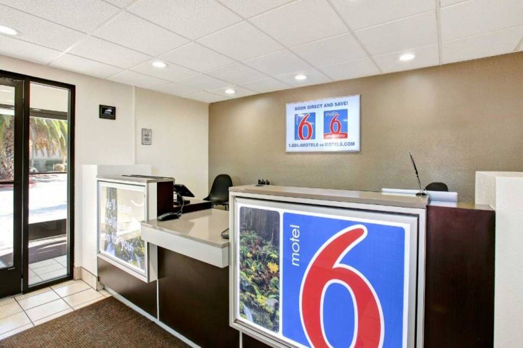 A reception desk with a sign for a motel named '6' and a phone.