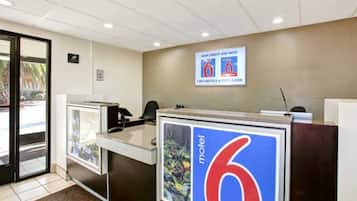 A reception desk with a sign for a motel named '6' and a phone.