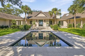 A two-story house with a central courtyard featuring a reflective water feature.