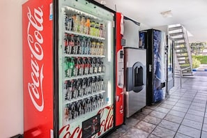 Area con distributore automatico, una macchina Coca-Cola e un frigorifero.