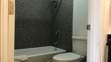 A bathroom with a bathtub, toilet, and shower.