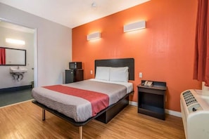Una habitación de hotel con una cama, mesitas de noche, un teléfono y un calentador.