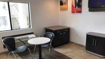 A small office space with a desk, two chairs, a radiator, and a cabinet.