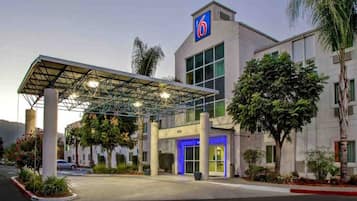 A hotel with a covered entrance, a prominent '6' sign, and a well-maintained exterior.
