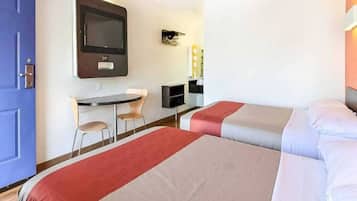 A hotel room with two beds, a desk, a chair, and a television.