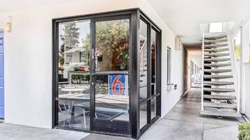A hotel entrance with a glass door, a visible sign for room number 6, and a staircase to the right.