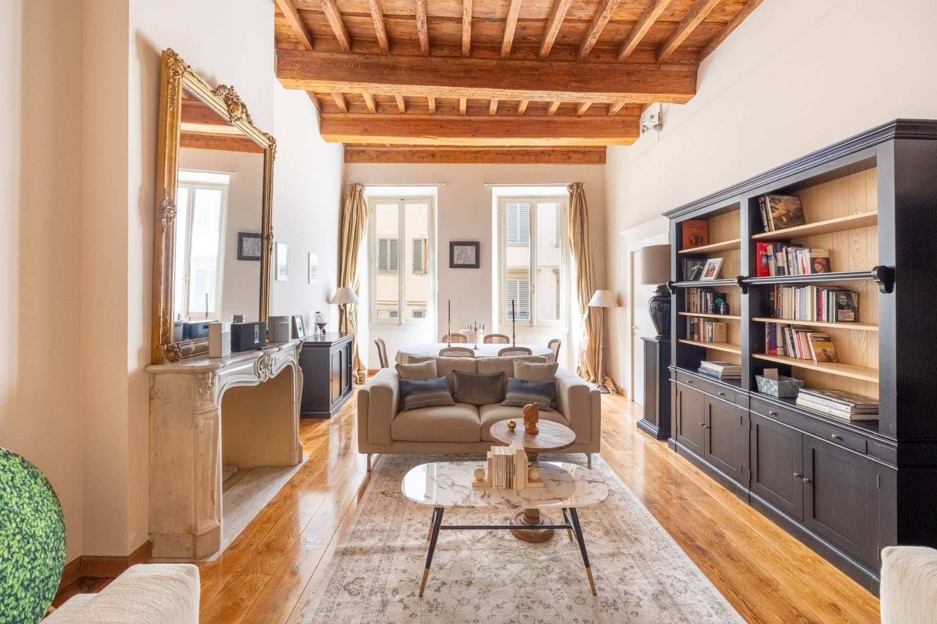 Una sala de estar con sofá, mesa de centro y estantería.