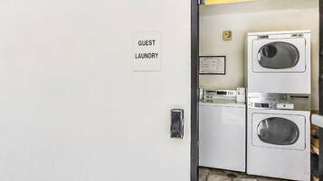 A guest laundry area with a sign, a washing machine, and a dryer.