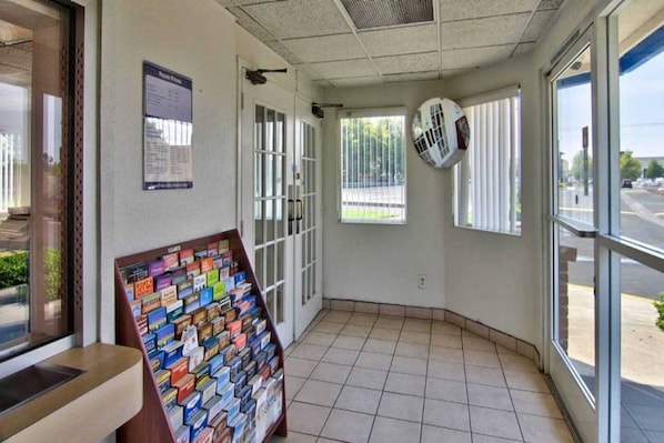 A corner room with a tiled floor, a bulletin board with various items, and a window with blinds. - 2 Queen Beds | NSMK, Micfridge (Sacramento CA)