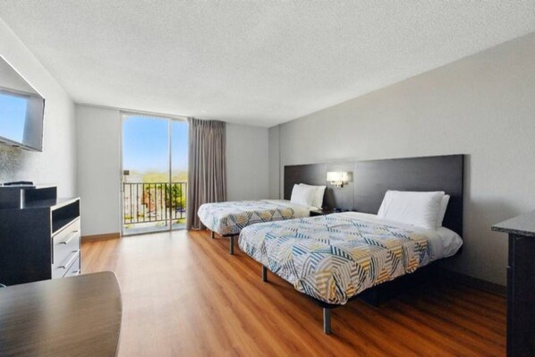 A hotel room with two beds, a desk, a TV, and a balcony with a view. - 2 Queen Beds | NSMK, Micfridge (Sacramento CA)
