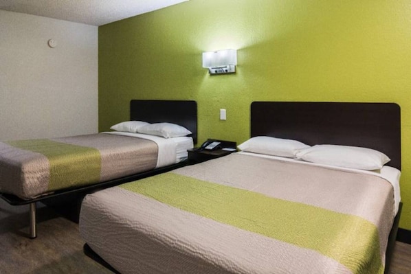 A hotel room with two single beds, a bedside table with a phone, and a wall-mounted light fixture. - 2 Full Beds | Deluxe, Micfridge (Sacramento CA)