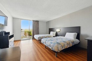 A hotel room with two beds, a desk, a TV, and a balcony with a view. - 2 Full Beds | Deluxe, Micfridge (Sacramento CA)