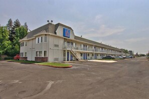 A motel with a single-story structure, a parking lot, and a small landscaped area. - 2 Full Beds | Deluxe, Micfridge (Sacramento CA)
