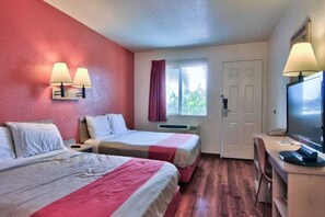 A hotel room with two beds, a desk with a computer, a TV, and a window with curtains. - Cozy 2 Full Beds | Micfridge, Smoking (Sacramento CA)