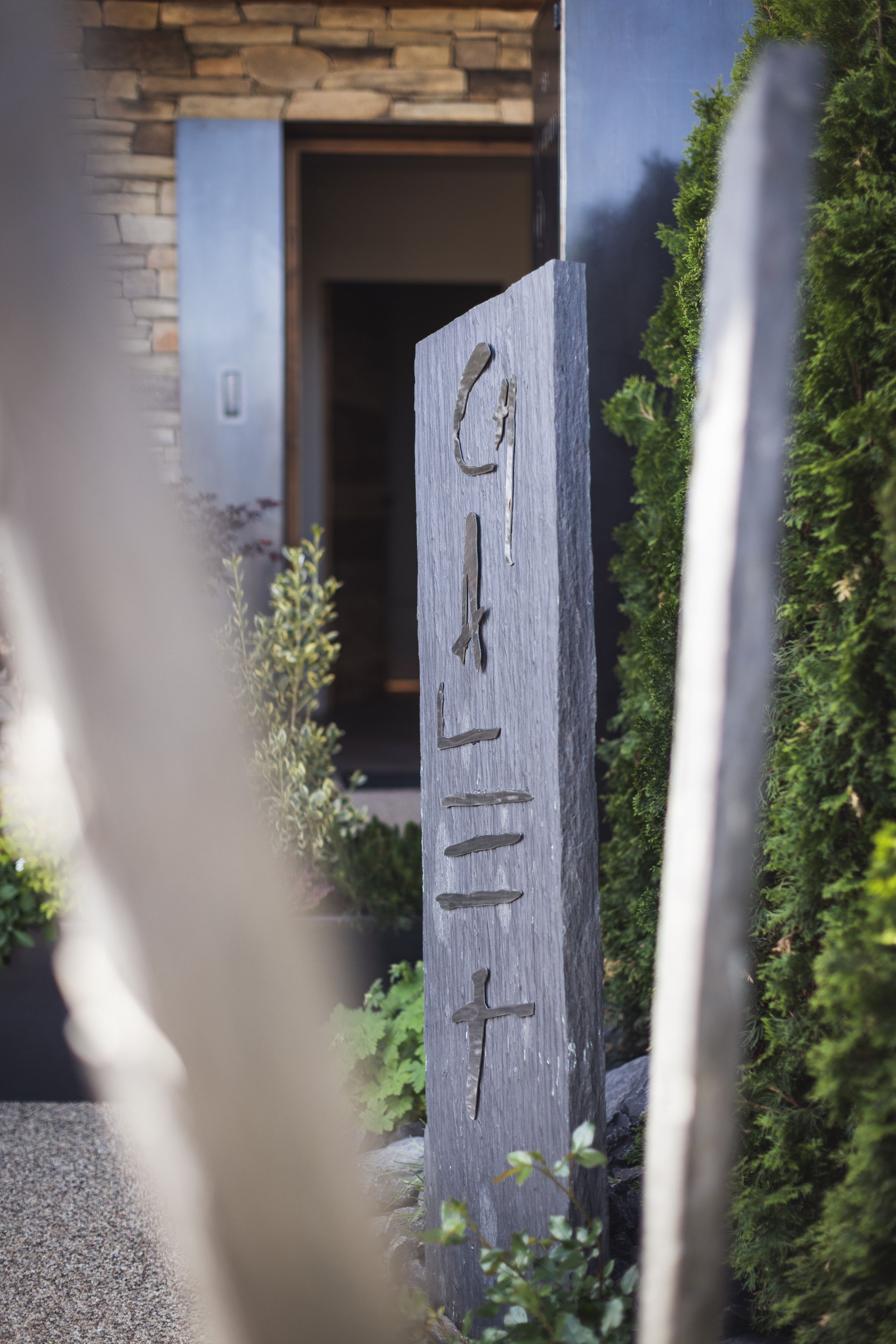 A stone sign with the inscription 'GILLET' in a garden setting.