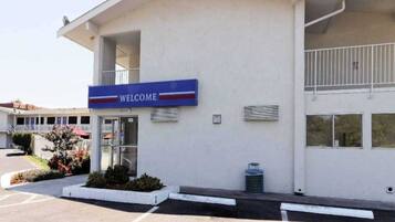 A building with a 'WELCOME' sign, a covered entrance, and a parking lot.