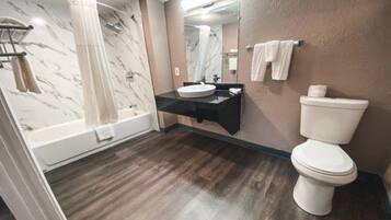 A bathroom with a bathtub, a toilet, and a sink.